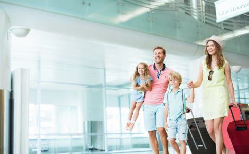 Familie mit zwei Kindern steht am Flughafen
