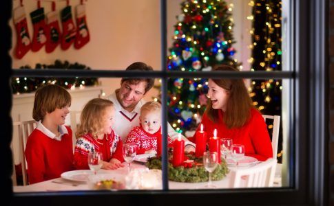 Familie mit Kleinkind beim Weihnachtsessen im Wohnzimmer