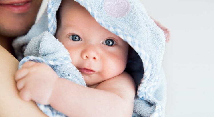 NeugeNahaufnahme eines Neugeborenen im Tuch auf dem Arm seiner Mutter
