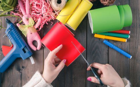 Frau bastelt auf Holztisch ein Geschenk