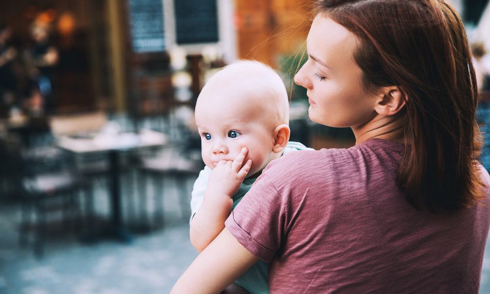 Ein Baby im Sommer auf dem Arm seiner Mutter