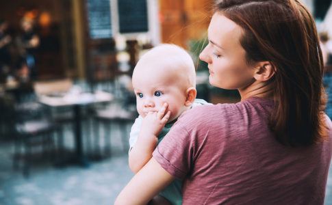 Ein Baby im Sommer auf dem Arm seiner Mutter