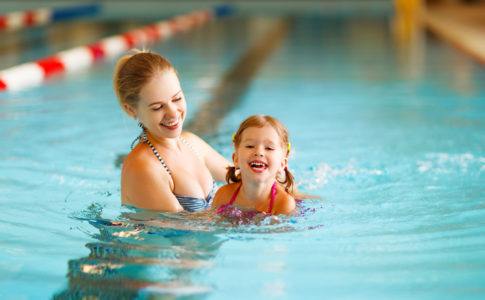 Mutter und Kind üben schwimmen