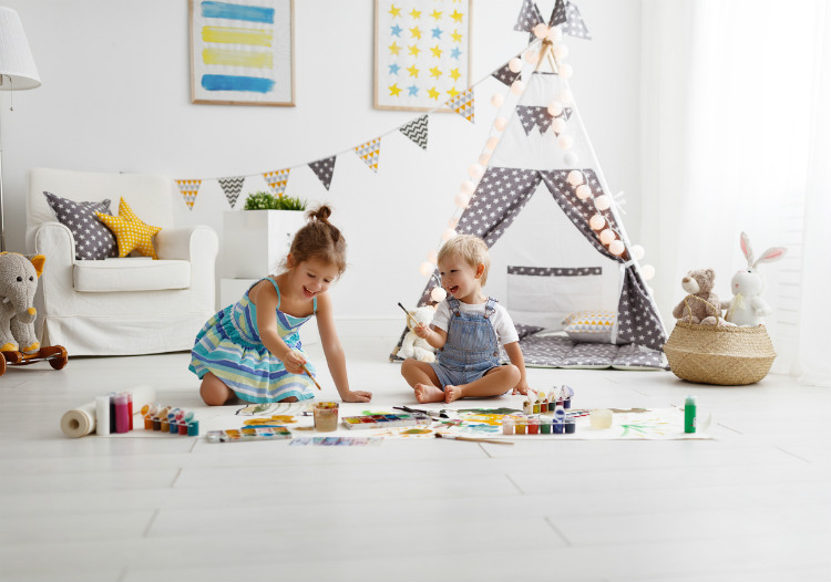 2 Kinder sitzen im Kinderzimmer und spielen miteinander