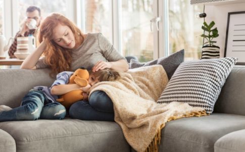 Mutter sitzt auf dem Sofa mit ihrem Kind