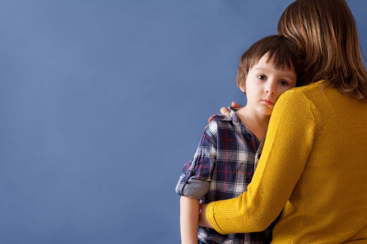 Unterhaltzahlungsbedürftiges Kind schaut über die Schulter der Mutter