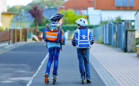 Zwei Kinder mit Schulranzen auf den Rücken