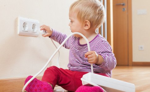 Baby spielt mit Steckdose