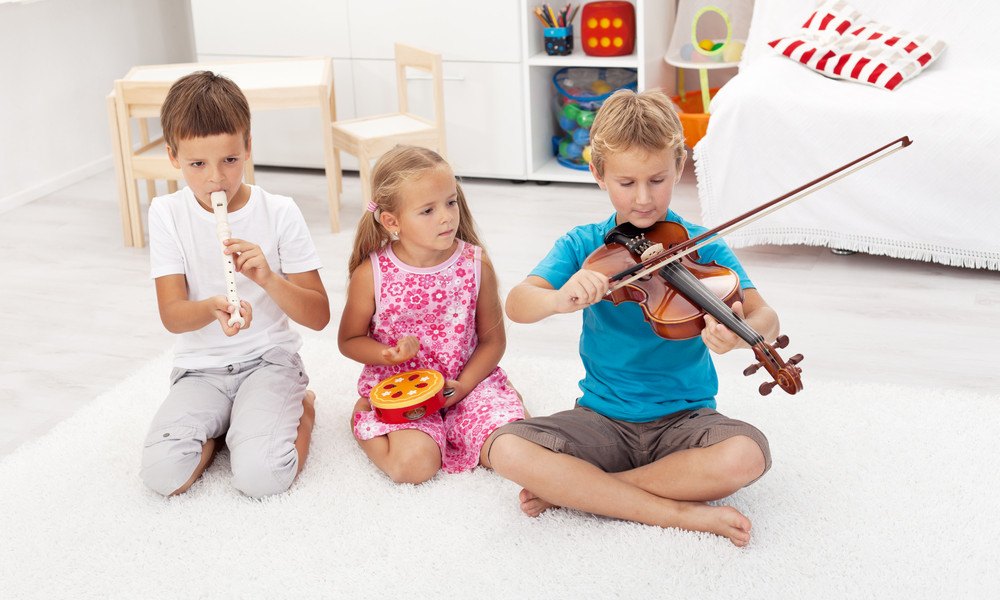 Kinder spielen mit Instrumenten auf Boden
