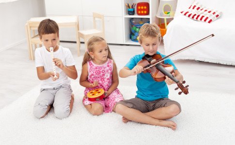Kinder spielen mit Instrumenten auf Boden